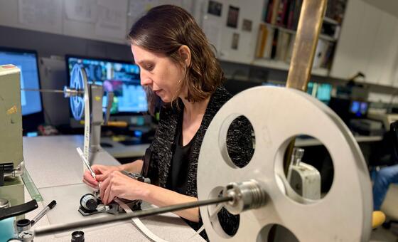 Casey McNamara, Media Preservation Coordinator, checks film tape for damage.